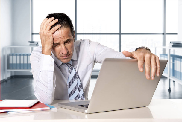 homme d'affaires senior désespéré en crise travaillant sur ordinateur portable au bureau dans le stress sous pression
  - Photo, image