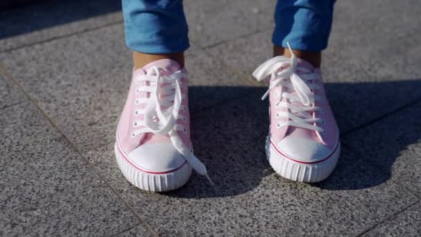 vrouwelijke handen koppelverkoop schoenveter op trendy roze gumshoes of sneakers - Video