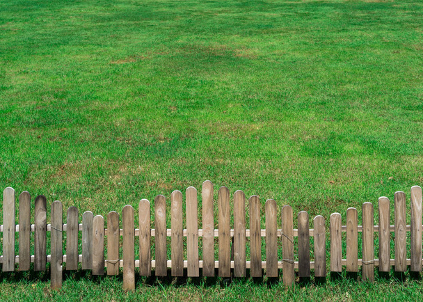 Valla de madera pequeña en el campo de hierba verde
 - Foto, imagen