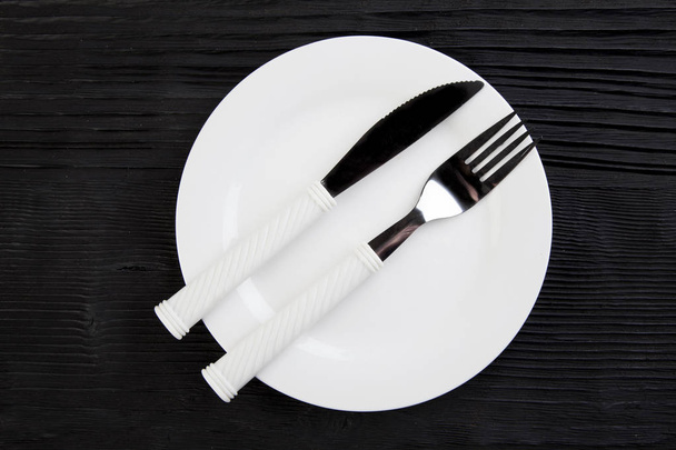  wooden background  black plate fork knife top view photo - Φωτογραφία, εικόνα