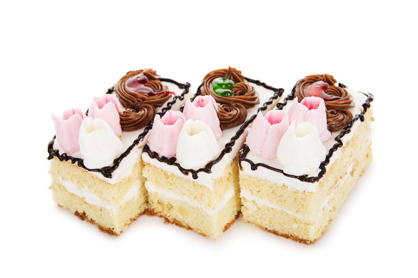 Biscuit witte cake versierd met crèmekleurige bloemen geïsoleerd op whit - Foto, afbeelding