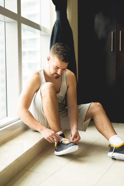 Sportsman putting sneakers on - Photo, Image