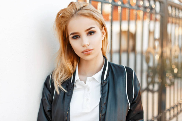 Beautiful girl student in jacket and polo shirt near college - Photo, image