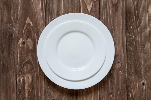 Δύο λευκό κεραμικό πιάτο σε φόντο ξύλινη - Φωτογραφία, εικόνα