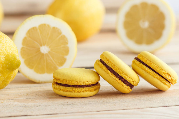 Yellow french macarons with lemons on the wooden boards - Foto, immagini