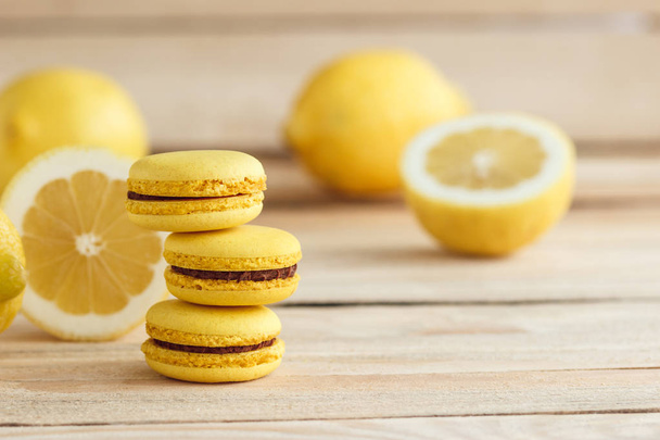 Yellow french macarons with lemons on the wooden boards - Foto, Bild