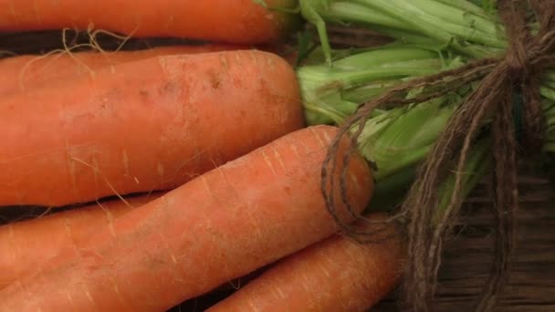 Ramo de zanahorias frescas sobre fondo rústico de madera - Imágenes, Vídeo