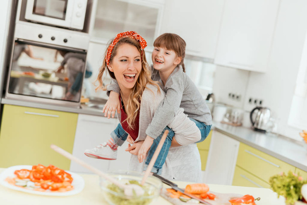 Девочка и мать готовят на кухне
 - Фото, изображение
