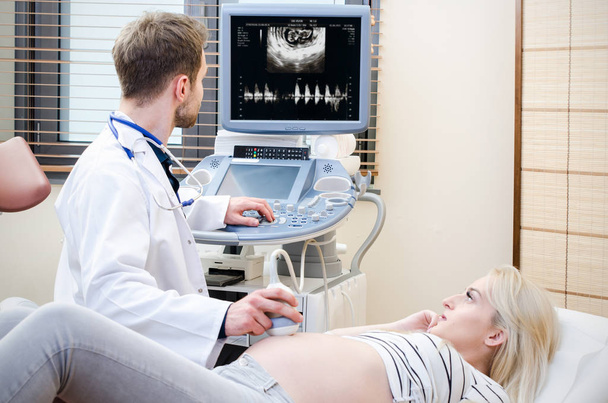 Pregnant woman at the doctor. Ultrasound diagnostic machine - Photo, Image
