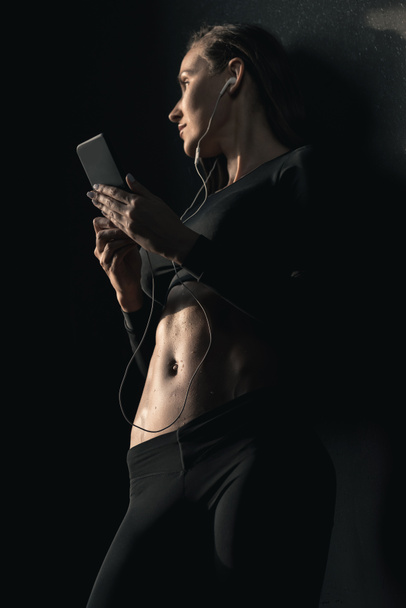 Sportos nő használ smartphone  - Fotó, kép