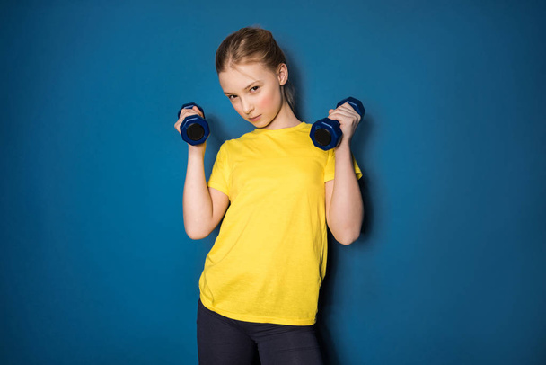 preteen girl training with dumbbells - Photo, image