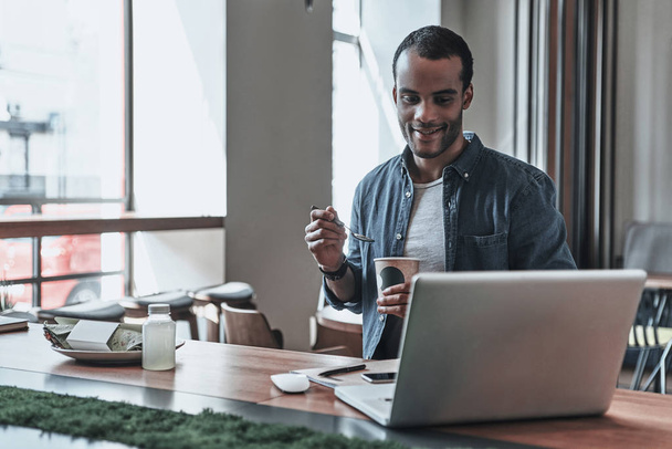 man drinking coffee and looking on laptop - Photo, Image