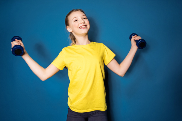 preteen girl training with dumbbells - Photo, image