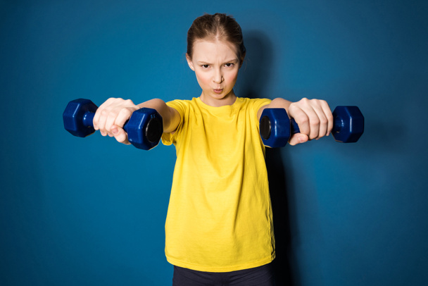 preteen girl training with dumbbells - Photo, Image