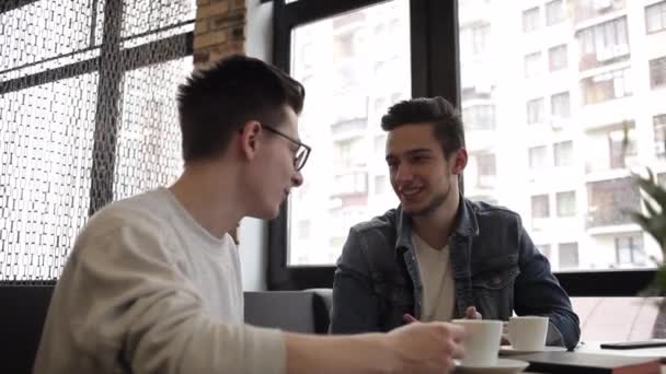 Dva kamarádi sedí v kavárně a chatování s sebou - Záběry, video