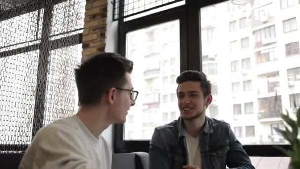 Dwóch kumpli, siedząc w kawiarni i rozmawiania ze sobą - Materiał filmowy, wideo