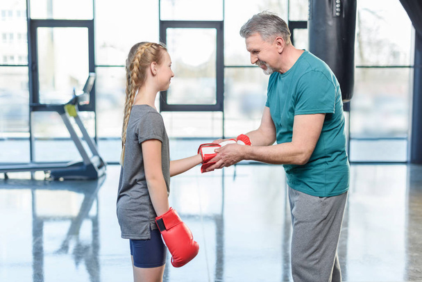 Preteen meisje boksen met trainer. - Foto, afbeelding