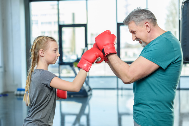 preteen girl boxing with trainer. - Foto, afbeelding