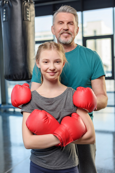 Preteen meisje boksen met trainer. - Foto, afbeelding