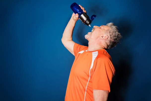 Зрелый спортсмен с бутылкой
  - Фото, изображение