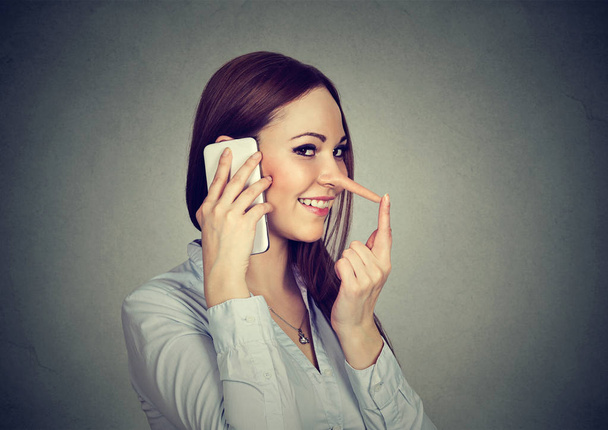 Happy young woman with long nose talking on mobile phone  - Foto, Bild