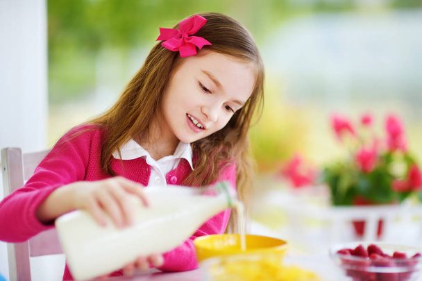 Pretty child purring milk in bowl  - Zdjęcie, obraz