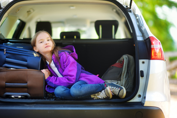  girl lying on suitcases in trunk of car  - Photo, image