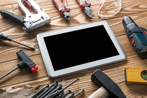 tools of builder and tablet pc on table - Фото, изображение