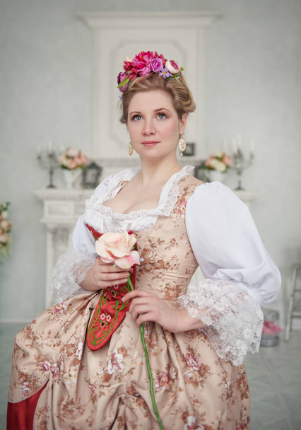 Красивая женщина в средневековом платье с розой
 - Фото, изображение