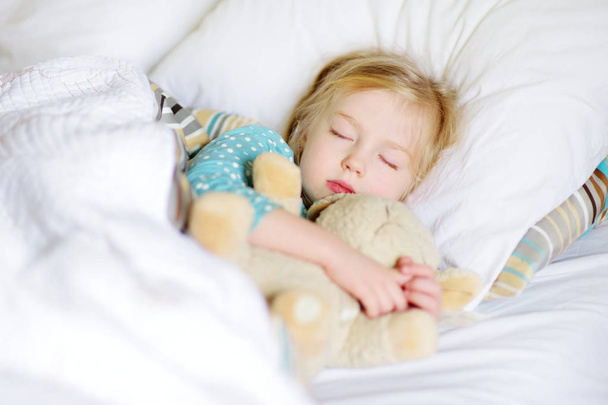 Adorable little girl sleeping in bed - Фото, изображение