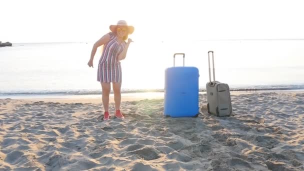 Gelukkig jonge vrouw reiziger dansen op het strand - Video