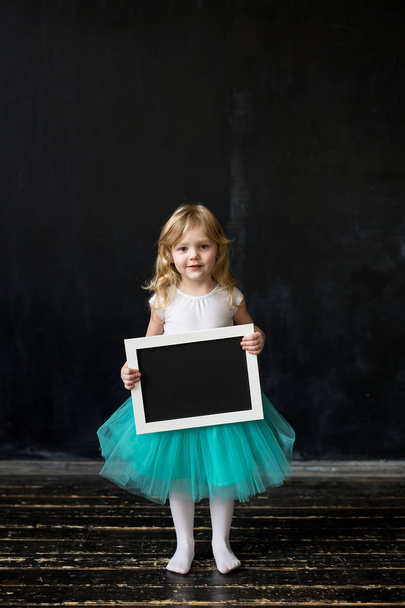 Το χαριτωμένο μικρό κορίτσι με ένα πλαίσιο στα χέρια της - Φωτογραφία, εικόνα