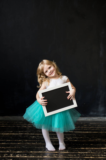 Girl  holding a black chalk board with empty blank space for you - Fotografie, Obrázek