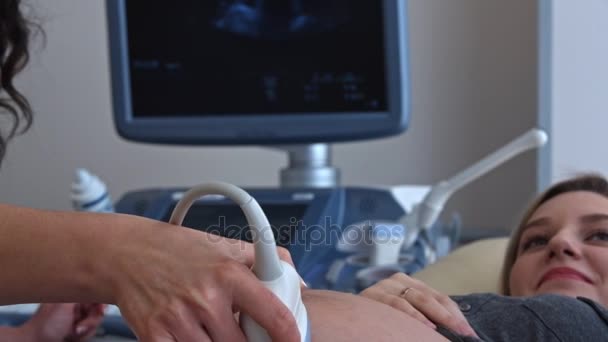 Arts met behulp van echografie apparatuur op de buik van zwangere vrouw. - Video