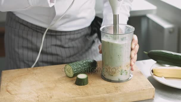Cocinero joven en uniforme preparando batido verde
 - Metraje, vídeo