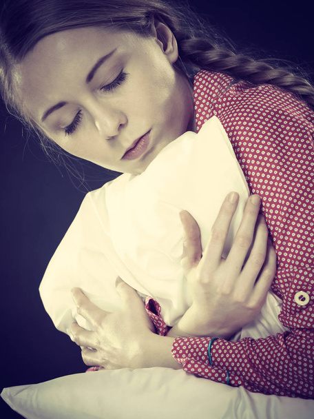 Sad depressed girl in bed gripping pillow - Foto, imagen
