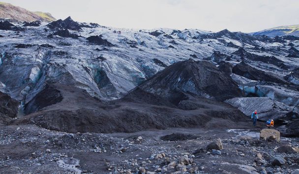 Icelandic Glacier with a group of hikers hiking tourists climbing exploring the famous glacier in Iceland - Foto, imagen