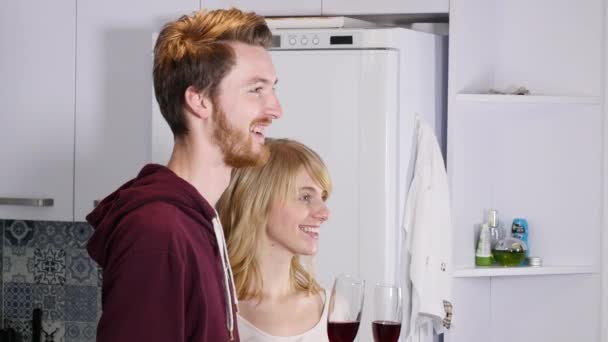 Jeune couple buvant du vin rouge dans la cuisine à la maison
 - Séquence, vidéo