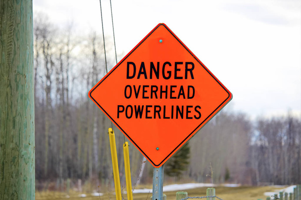 Danger overhead powerline sign beside a power pole - Photo, Image