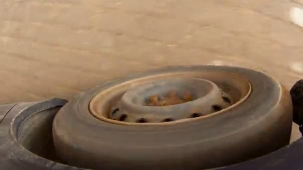 Válcování Gumové pneumatiky tmavě modré auto na asfaltovou silnici. - Záběry, video