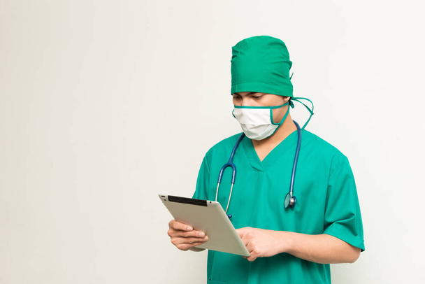 Asian male medical doctor using tablet on white background - Foto, Imagen