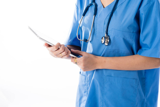 Female Asian nurse using a digital tablet & wearing a blue coat - Foto, imagen