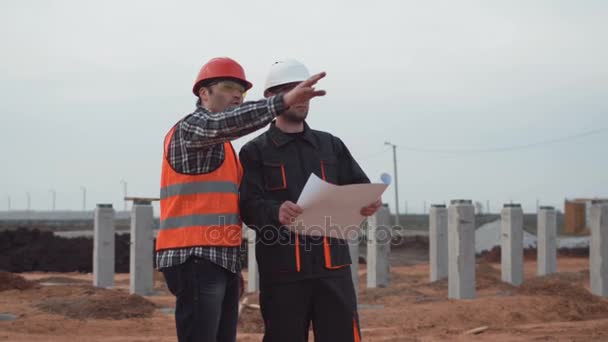 Men in uniform near columns discussing the blueprint - Кадри, відео