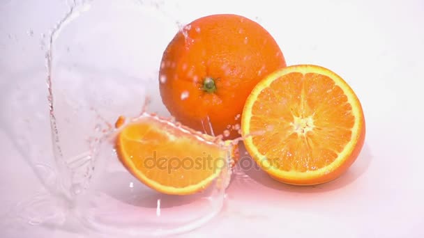 Rebanadas de naranja caen sobre la mesa
. - Metraje, vídeo