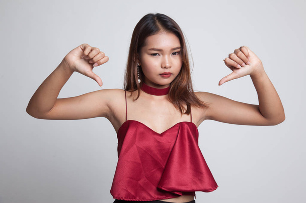 Unhappy Asian girl show thumbs down with both hands. - 写真・画像