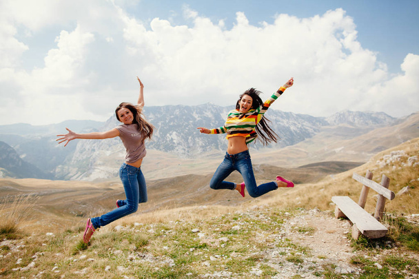 mujeres felices viajan y saltan juntas
 - Foto, imagen
