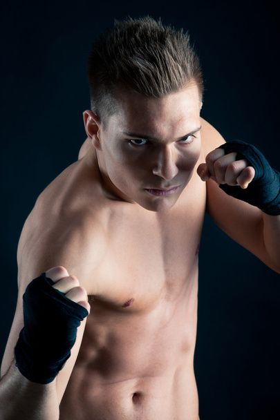 Sportsman boxer close up portrait against black background - 写真・画像