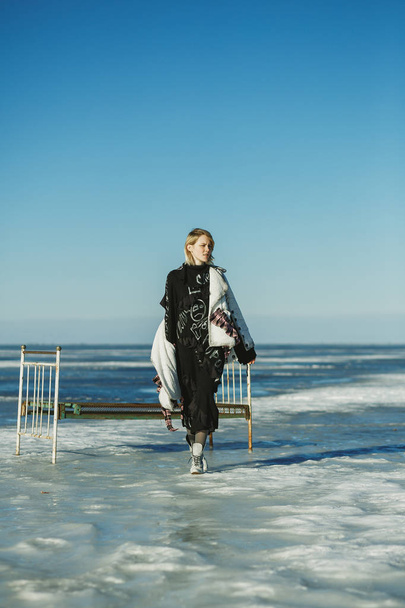 A girl in old clothes walks on ice against the frozen sea and an - Photo, Image