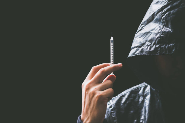 dangerous asian male drug addict holding syringe in hand - Фото, зображення