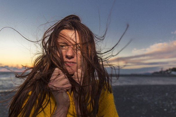Young beautiful long hair woman on windy seashore - Fotoğraf, Görsel